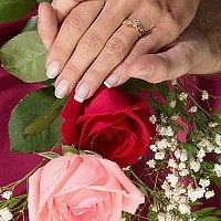 newly remarried couple holding hands with wedding flowers
